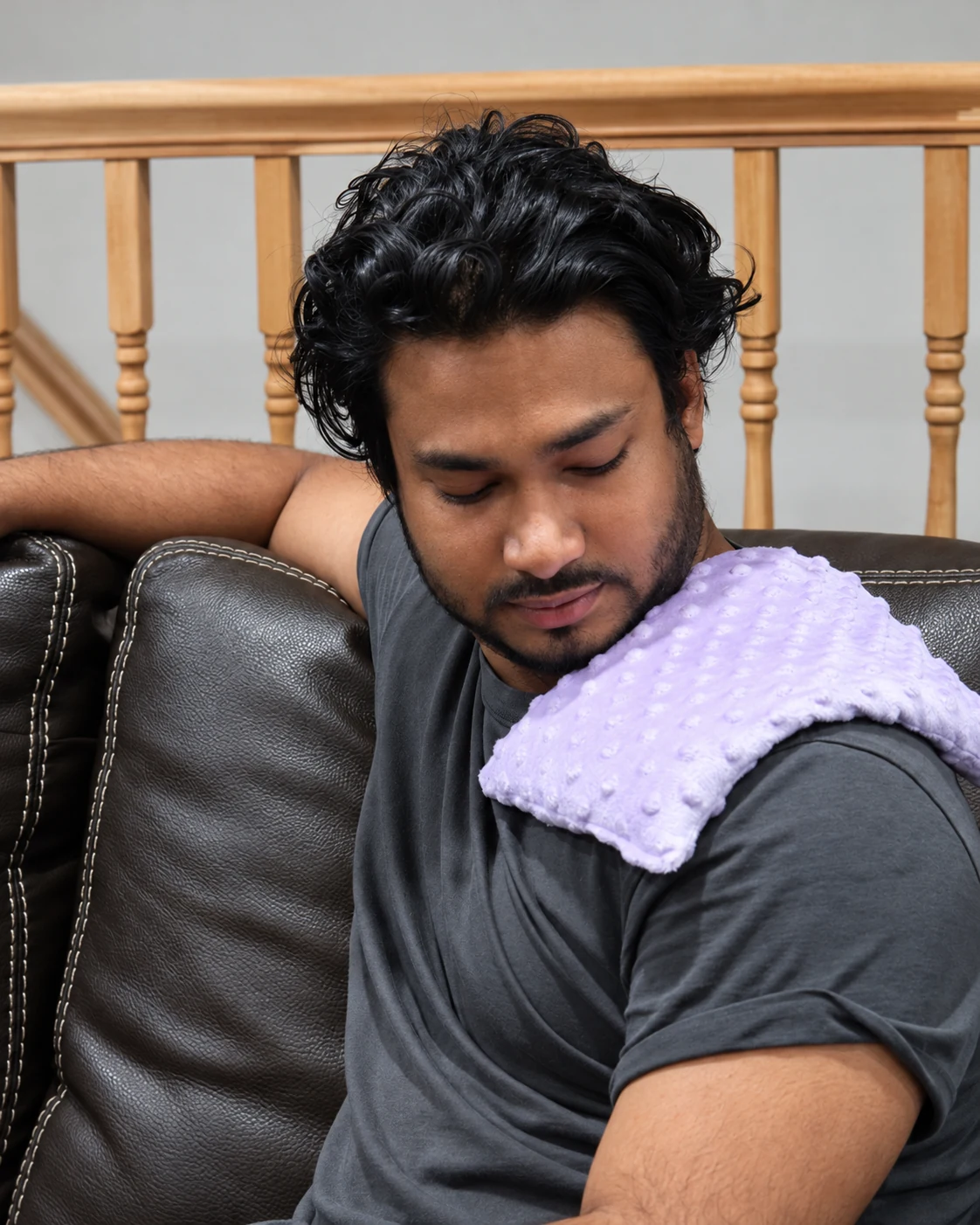 Shekh resting with a soft heating pad on his shoulder